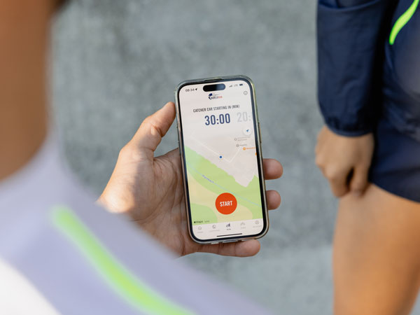Um participante na corrida está a verificar o telemóvel, à espera que a corrida comece.