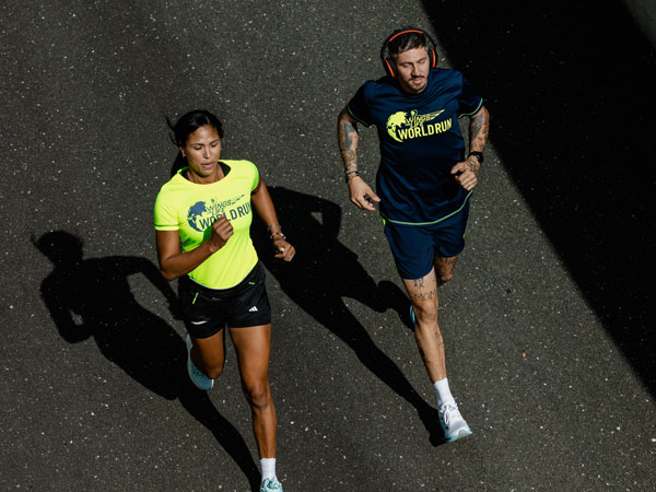 Dois corredores a correr para se manterem à frente do carro virtual.